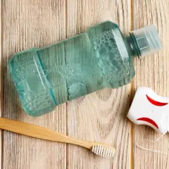 Zestaw do higieny jamy ustnej: płyn, nić dentystyczna i bambusowa szczoteczka. Pomoc w walce ze spuchniętym dziąsłem.